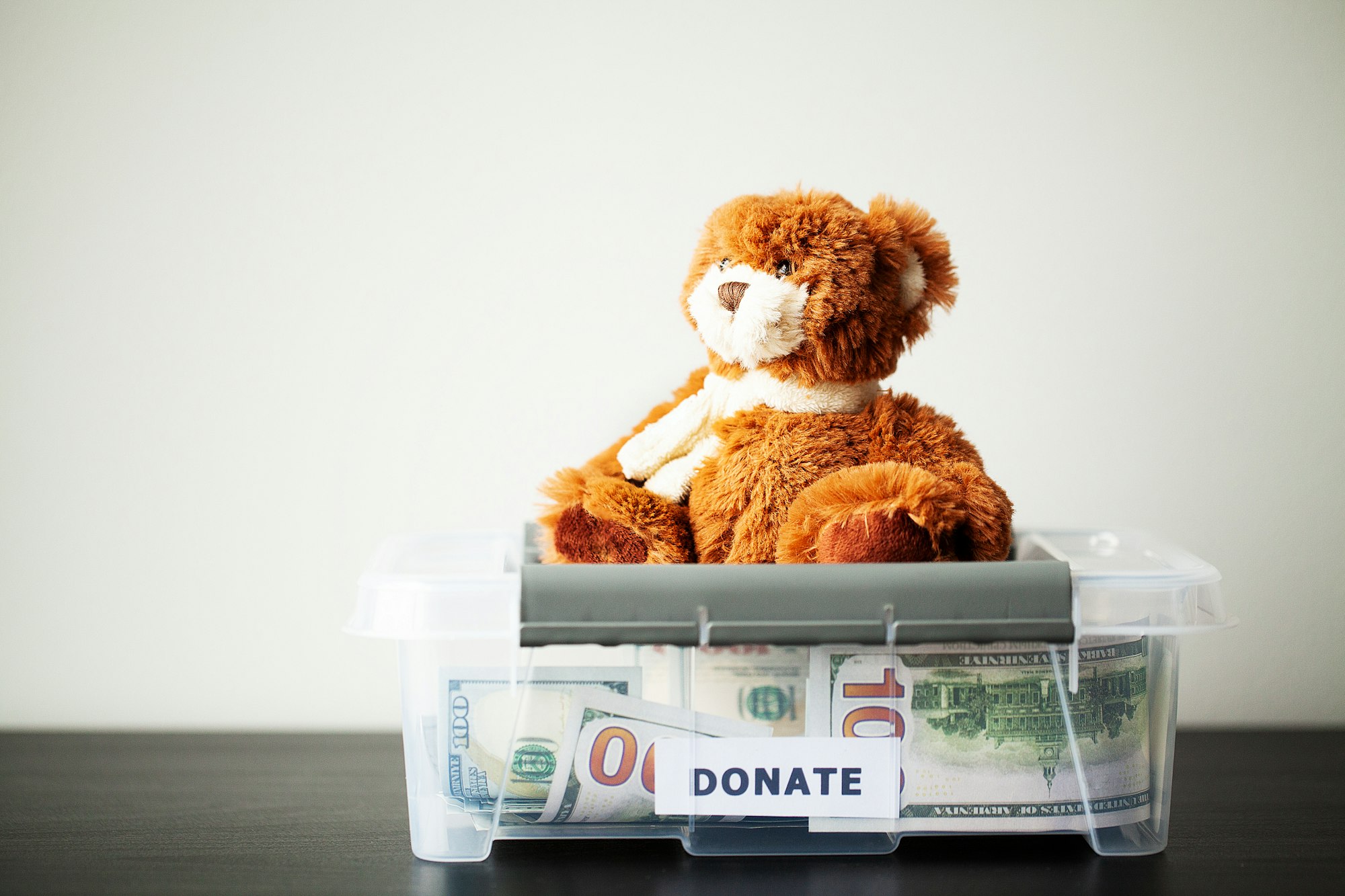 Donate box with dollars on wood desk